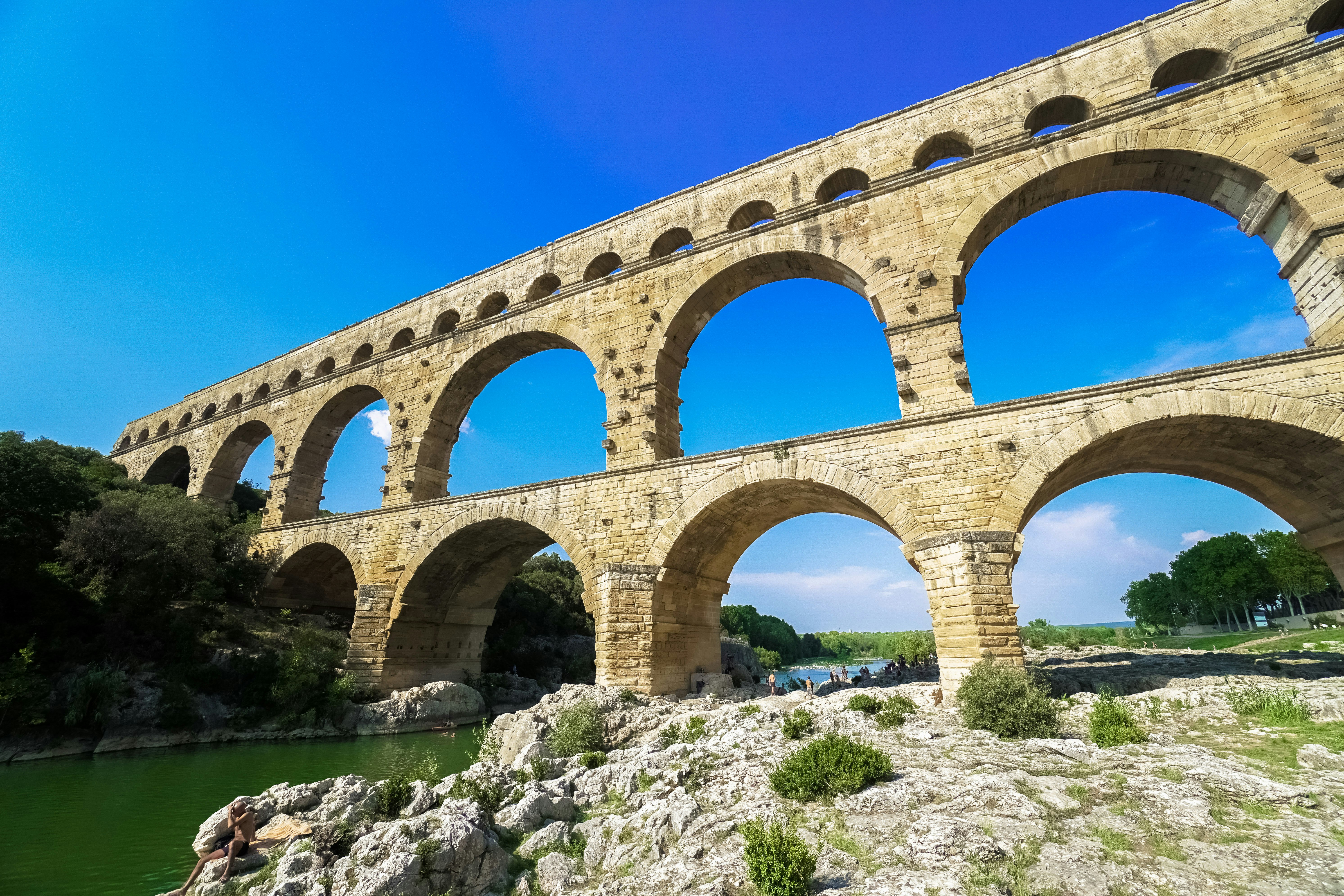 brown concrete bridge over river under blue sky during daytime